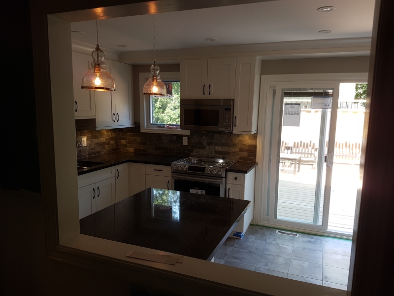 A newly renovated kitchen, with new appliances and sliding door to a deck.